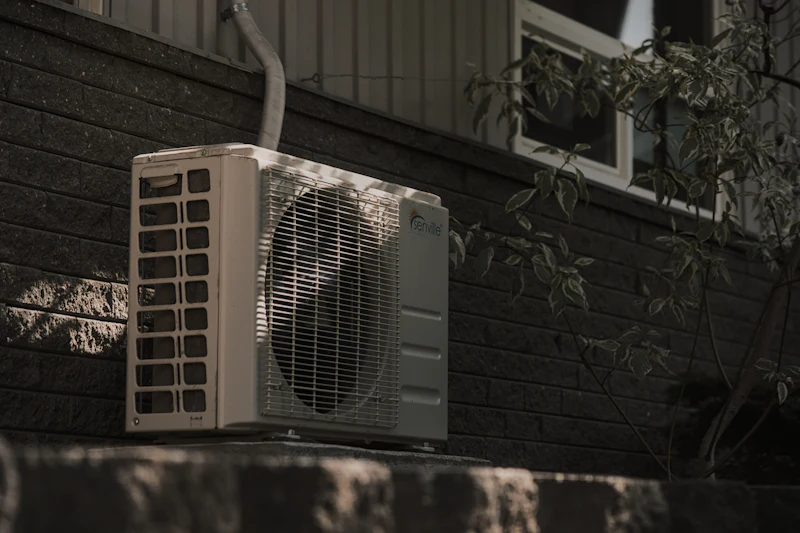 Outdoor air conditioning condenser unit beside a home